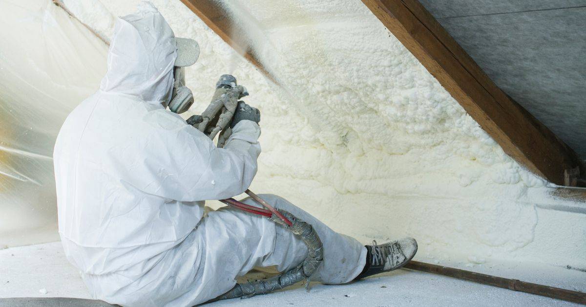 Insulation contractor injecting spray foam insulation